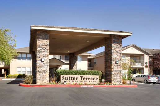 Sutter Terrace sign with large covered stone front entrance drive through in parking lot